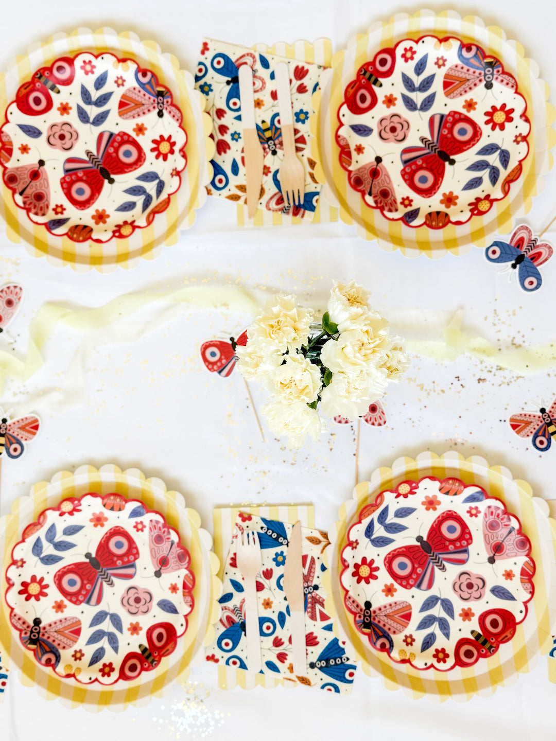 Whimsical butterfly-themed party setup with layered yellow gingham plates